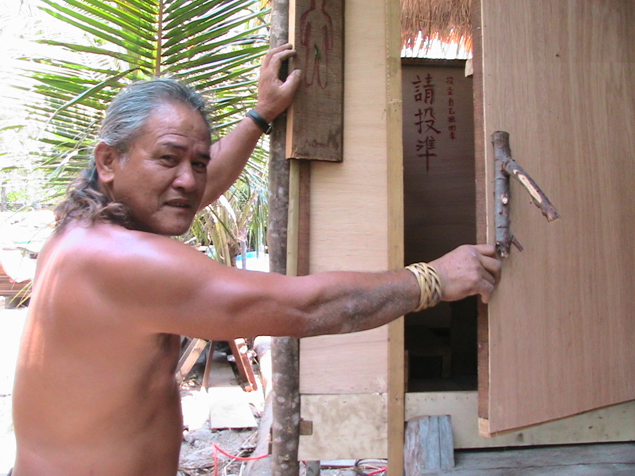 十八般武藝樣樣俱全的總幹事Lawai,與他「監製」的生態廁所合影。注意樹枝門把。照片提供：大苑